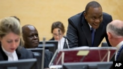FILE - Kenya President Uhuru Kenyatta, second right, talks to his defense team when appearing before the International Criminal Court (ICC) in The Hague, Netherlands, Oct. 8, 2014.