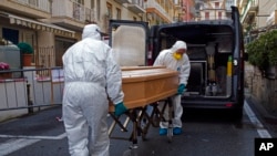 Anggota staf medis yang mengenakan baju pelindung, membawa peti jenazah Assunta Pastore, 87 tahun, salah satu dari grup turis lansia di kawasan Lombardia, yang dites positif virus korona, Minggu, 1 Maret 2020. (Foto: Reuters)