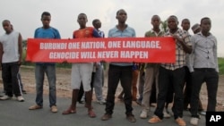 Young men hold a banner on the road that the convoy of the United Nations Security Council delegation took in Bujumbura, Burundi, Jan. 21, 2016. 