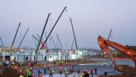 Construction workers labor at the site of the Huoshenshan temporary field hospital being built in Wuhan in central China's Hubei Province, Thursday, Jan. 30, 2020. (AP Photo/Arek Rataj)