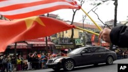 Warga Vietnam menunggu di jalan-jalan yang dilalui oleh iringan kendaraan Presiden AS Donald Trump di Hanoi, Selasa (26/2). 