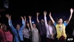 Volunteers celebrate at a makeshift press centre in Mae Sai district of Chiang Rai province on July 10, 2018, after the 12 boys and their soccer coach were rescued.