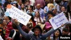 FILE - Demonstrators hold aloft placards during a rally in support of refugees that was part of a national campaign in central Sydney, Australia, Oct. 11, 2015. 