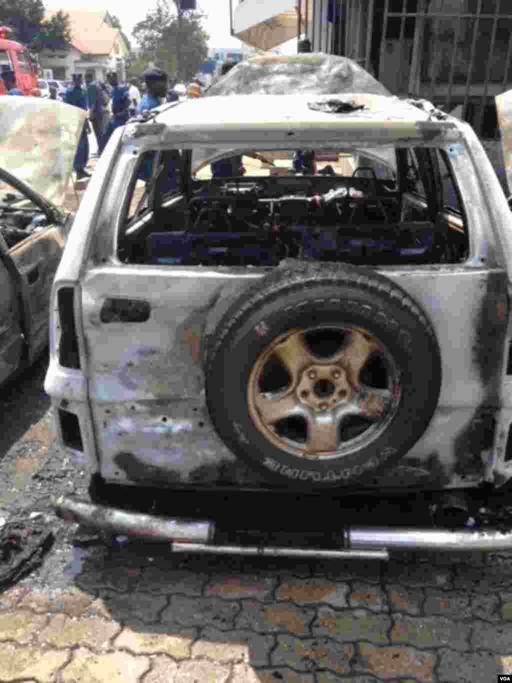 Un des trois véhicules endommagés et incendiés à la suite de l&#39;explosion d&#39;une grenade près de la Banque commerciale du Kenya à Bujumbura, Burundi vendredi 29 mai 2015. (Edward Rwena - VOA)