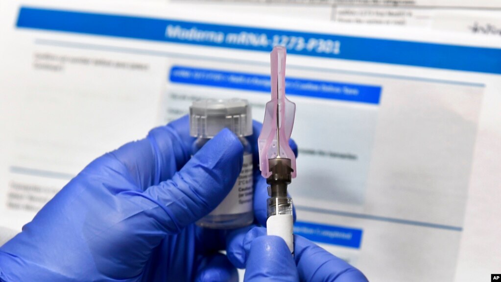 FILE - In this Monday, July 27, 2020 file photo, a nurse prepares a shot as a study of a possible COVID-19 vaccine, developed by the National Institutes of Health and Moderna Inc., gets underway in Binghamton, N.Y. 