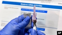 Seorang perawat menyiapkan vaksin COVID-19 yang dikembangkan oleh National Institutes of Health and Moderna Inc. (Foto: AP)