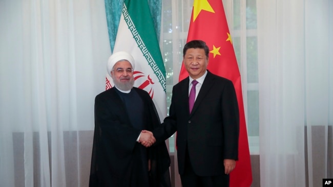 图为伊朗总统鲁哈尼与中国国家主席习近平握手。(2019年6月14日)