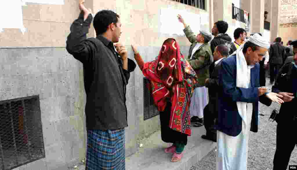 Voters scan the lists at a polling station in Sana'a, February 21, 2012. (E. Arrott/VOA)