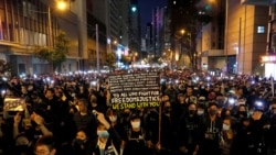 香港示威者星期天（12月8日）在人權日大遊行中下打開手機電筒。