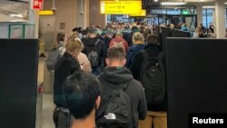 Passengers travelling from South Africa queue to be coronavirus disease (COVID-19) tested after being held on the tarmac at Schiphol Airport, Netherlands, Nov. 25, 2021.