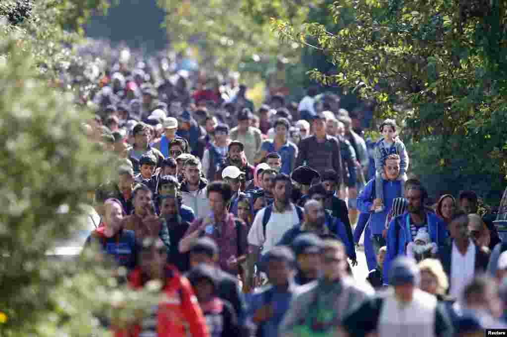 Migrants walk towards the Austrian border from Hegyeshalom, Hungary, Sept. 23, 2015. European Union leaders could promise billions of euros in new funding for Syrian refugees at an emergency summit where they will also try to patch up bitter divisions over the migration crisis.