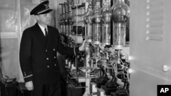 FILE - Coast Guard Ensign Henry H. Lodge, seen March 2, 1952, looks over big glass tubes of a high voltage rectifier unit aboard the Coast Guard Cutter Courier.