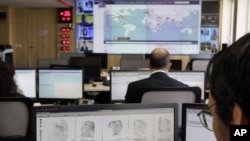 Interpol employee looks at finger prints in the control room of the Interpol headquarters in Lyon, central France, file photo. 