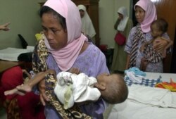 Para ibu menggendong anaknya yang menderita gizi buruk di sebuah klinik di Bogor, Jawa Barat. (Foto: AP)