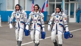 In this handout photo released by Roscosmos Space Agency Press Service U.S. astronaut Chris Cassidy, left, Russian cosmonauts Anatoly Ivanishin, centre, and Ivan Vagner, members of the main crew of the expedition to the International Space Station (ISS), walk prior the launch of Soyuz MS-16 space ship at the Russian leased Baikonur cosmodrome, Kazakhstan, Thursday, April 9, 2020. (Roscosmos Space Agency Press Service via AP)