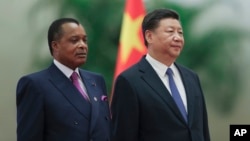 Chinese President Xi Jinping, right, and Congo President Denis Sassou Nguesso listen to their national anthems during a welcoming ceremony inside the Great Hall of the People in Beijing, Sept. 5, 2018.