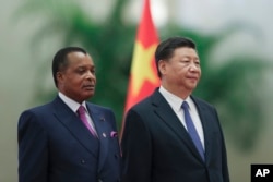 Chinese President Xi Jinping (R) and Congo President Denis Sassou Nguesso listen to their national anthems during a welcoming ceremony inside the Great Hall of the People in Beijing, Sept. 5, 2018.