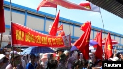 FILE - Workers wave Vietnamese national flags during an anti-China protest at a Chinese shoe factory in Vietnam's northern Thai Binh province, May 14, 2014.