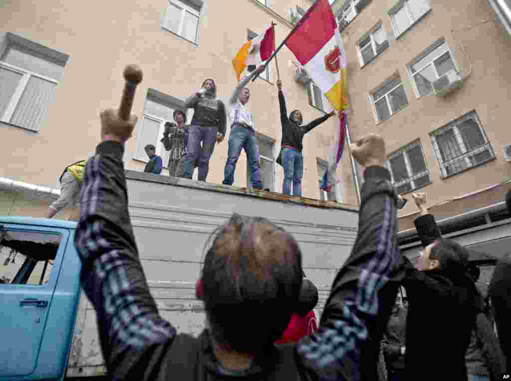 Pro-Russian protesters celebrate on top of a truck at a police station in Odessa, Ukraine, Sunday, May 4, 2014. Several prisoners that were detained during clashes that erupted Friday between pro-Russians and government supporters in the key port on the B