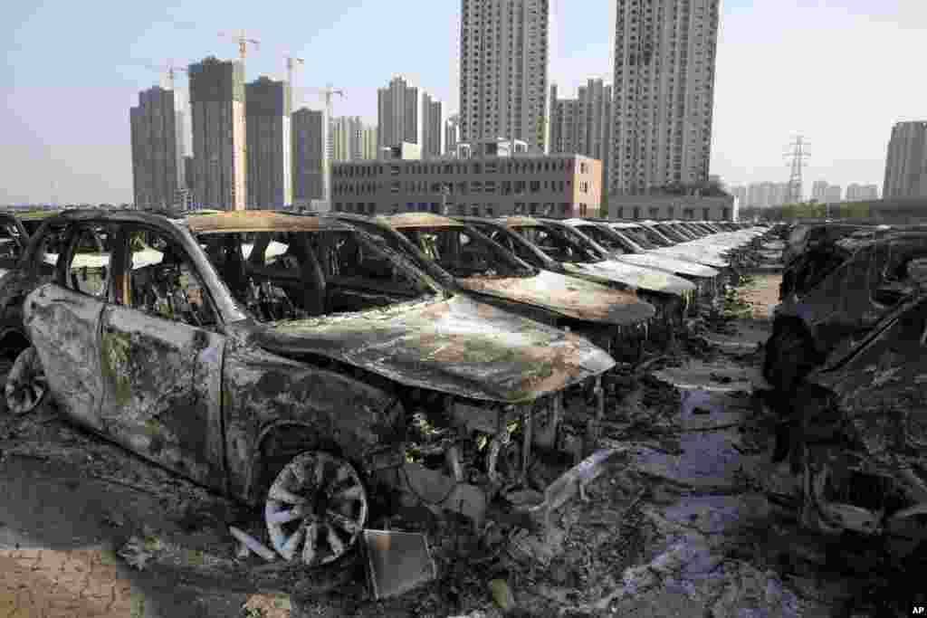 Rongsokan mobil-mobil yang tadinya baru akibat ledakan yang sampai ke lapangan parkir sebuah gudang di Tianjin, China (13/8).(AP/Ng Han Guan)