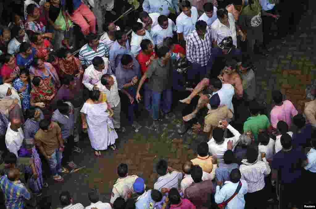 Rescue workers carry a man who was rescued from the rubble at the site of a collapsed residential building in Mumbai, Sept. 27, 2013. 