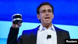 FILE - Ford Motor Co. CEO Mark Fields holds up a new Velodyne LiDAR sensor at a news conference at the Consumer Electronics Show in Las Vegas, Jan. 5, 2016. 