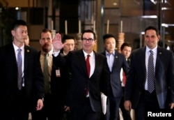 FILE - U.S. Treasury Secretary Steven Mnuchin, a member of the U.S. trade delegation to China, waves to the media as he returns to a hotel in Beijing, China, May 3, 2018.