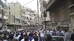 Mourners attend the funerals of protesters killed in earlier clashes in the Syrian city of Homs, April 18, 2011