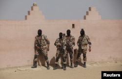 FILE - Pakistan Rangers stand before taking their positions during a counterterrorism training demonstration on the outskirts of Karachi, Feb. 24, 2015.