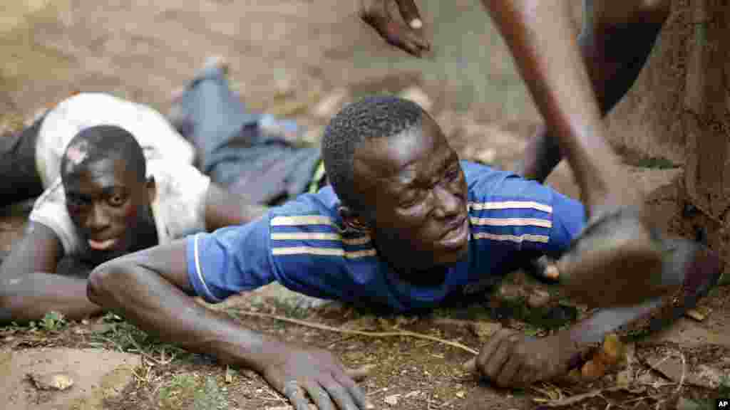 A plat ventre, cet homme se couvre de tirs à l&rsquo;arme lourde dans le district de Miskin à Bangui. Le 3 février 2014. 