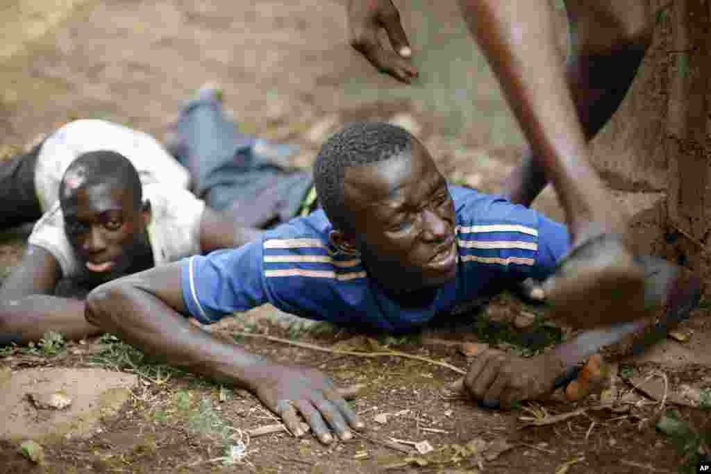 Men duck for cover as heavy gunfire erupts in the Miskin district of Bangui, Feb. 3, 2014.