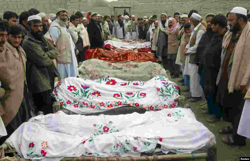 Villagers stand around the bodies of girls who were killed by an explosion in Jalalabad, Afghanistan, December 17, 2012.