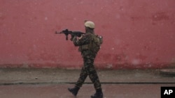 A member of Afghan security personnel arrives at the site of an attack at a military academy in Kabul, Afghanistan, Jan. 29, 2018. Afghan security forces arrested eight militants after members of the Islamic State group attacked a military academy in Kabul.