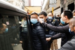 Stand News acting chief editor Patrick Lam, one of the six people arrested "for conspiracy to publish seditious publication" according to Hong Kong's Police National Security Department, is escorted by police as they leave after the police searched his office in Hong Kong, China, Dec. 29, 2021.
