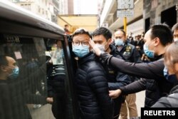 Stand News acting chief editor Patrick Lam, one of the six people arrested "for conspiracy to publish seditious publication" according to Hong Kong's Police National Security Department, is escorted by police as they leave after the police searched his office in Hong Kong, China, Dec. 29, 2021.