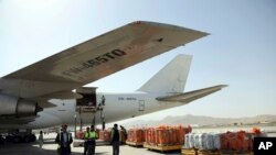 FILE - Airport workers load the first cargo plane after the Afghanistan-India air corridor inauguration ceremony at Hamid Karzai International Airport in Kabul, Afghanistan, June 2017.