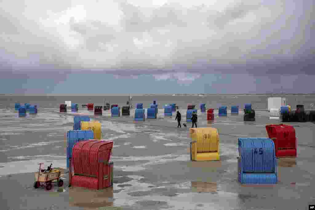 Dark clouds move over seaside chairs on the beach of Nessmersiel, Germany.