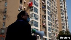 中国江西省九江市一个居民小区的居委会成员在宣传新冠防疫。（2020年2月4日）
