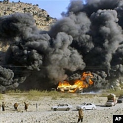 Residents look at burning oil tankers carrying fuel supplies for NATO forces, caused by a militant attack near Jamrud, in the Khyber tribal region along the Afghan border, 20 Dec 2010