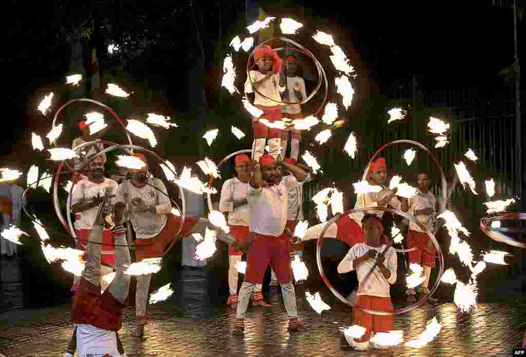 Fire dancers perform in front of the historic Buddhist Temple of the Tooth during the Esala Perahera festival in the ancient hill capital of Kandy, some 116 kilometers from Colombo, Sri Lanka, Aug. 3, 2020.