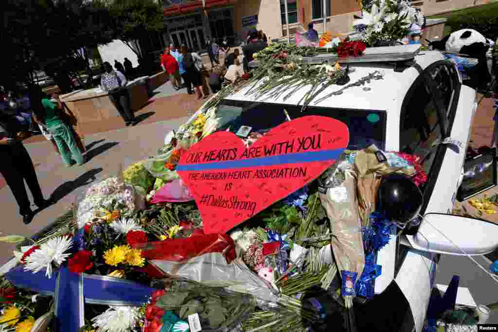 A heart is placed on a police car that makes up part of a makeshift memorial at police headquarters following the multiple police shooting in Dallas, Texas, July 8, 2016.
