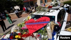 A heart is pictured on a police car that makes up part of a makeshift memorial at police headquarters following the multiple police shooting in Dallas, Texas, July 8, 2016.