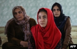 Women and young girls listen to Kurdistan Rasul (not pictured), an Iraqi Kurdish activist with the NGO WADI, as she speaks about the harm of genital mutilation in Sharboty Saghira, Iraq, Dec. 3, 2018.