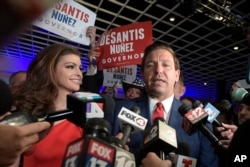 Florida Governor-elect Ron DeSantis, right, answers questions from reporters, with his wife Casey, after being declared the winner of the Florida gubernatorial race at an election party in Orlando, Fla., Nov. 6, 2018.