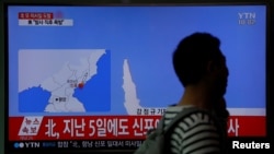 A passenger walks past a TV broadcasting a news report on North Korea's failed missile launch from its east coast, at a railway station in Seoul, South Korea, April 16, 2017. 