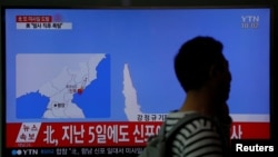 A passenger walks past a TV broadcasting a news report on North Korea's failed missile launch from its east coast, at a railway station in Seoul, South Korea, April 16, 2017.