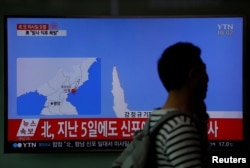 A passenger walks past a TV broadcasting a news report on North Korea's failed missile launch from its east coast, at a railway station in Seoul, South Korea, April 16, 2017.