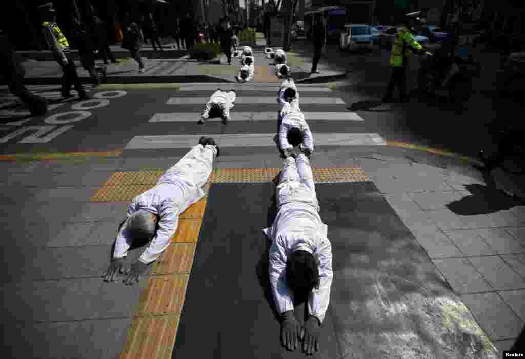 Buddhist believers perform during a &quot;three steps one bow&quot; ceremony&nbsp;in central Seoul to urge the government to salvage the sunken ferry Sewol as soon as possible.