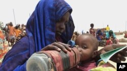 FILE - A mother quenches her malnourished child's thirst while waiting for food handouts at a health center in drought-stricken remote Somali region of Eastern Ethiopia, also known as the Ogaden, July 2011.