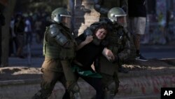 Oficiales de la policía detienen a un manifestante durante una protesta en Santiago, Chile, el sábado 7 de diciembre de 2019.
